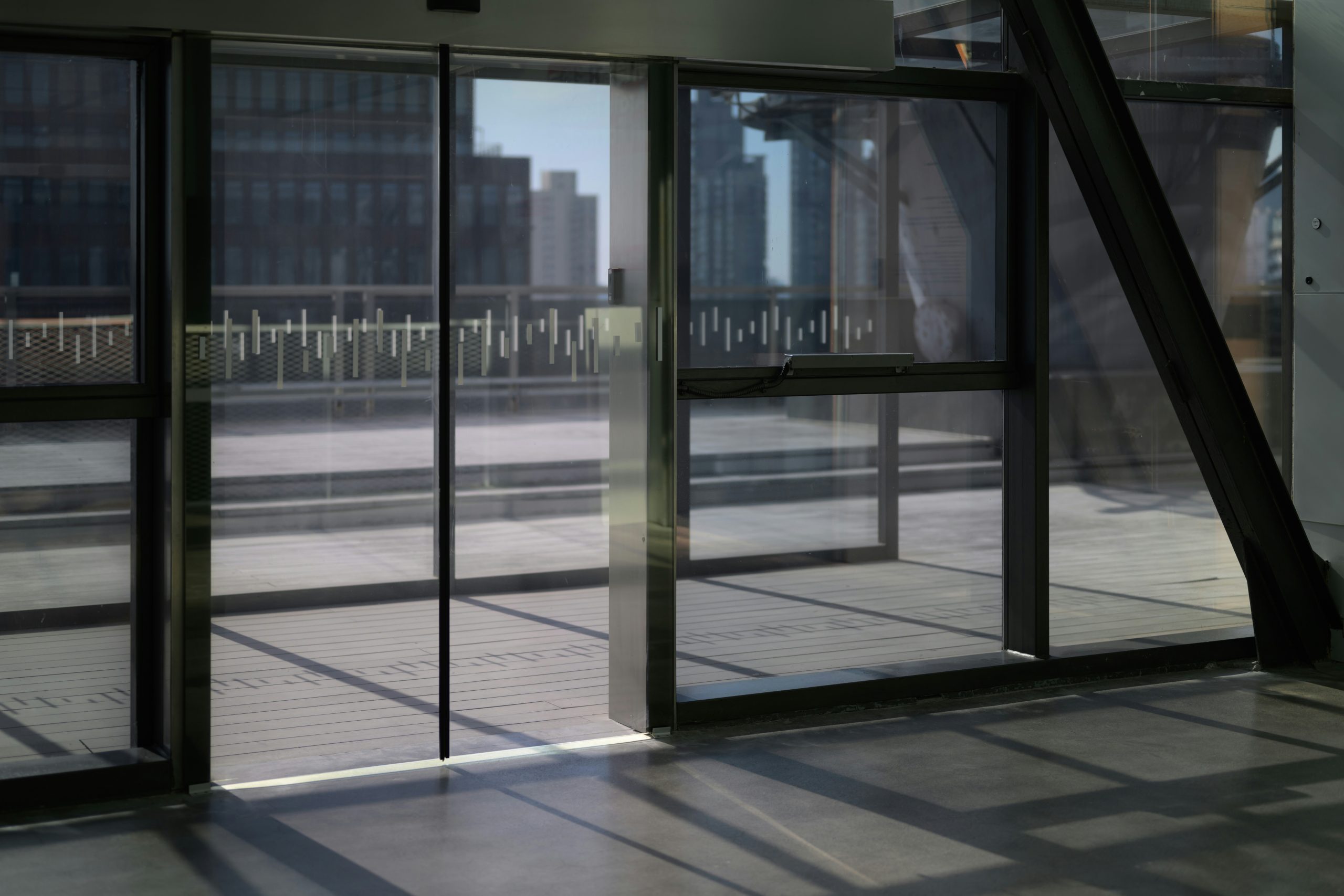 A frameless automatic glass sliding door at a commercial building entrance stuck closed during a power outage.